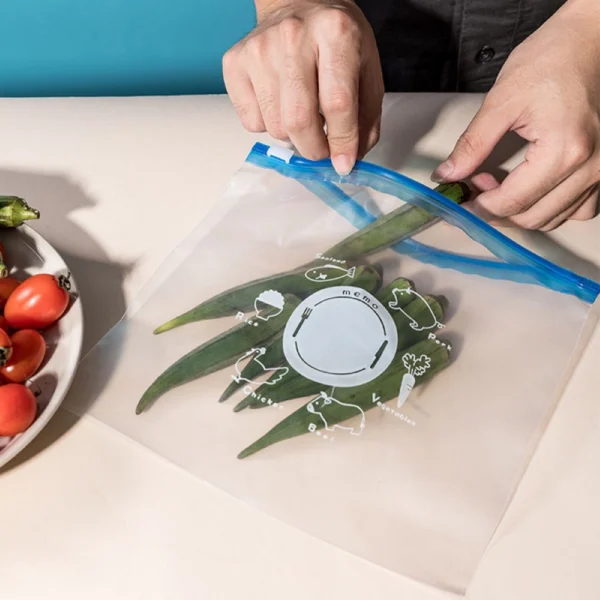 Hands sealing reusable vacuum pack food storage bags containing fresh vegetables using a secure slider zipper.
